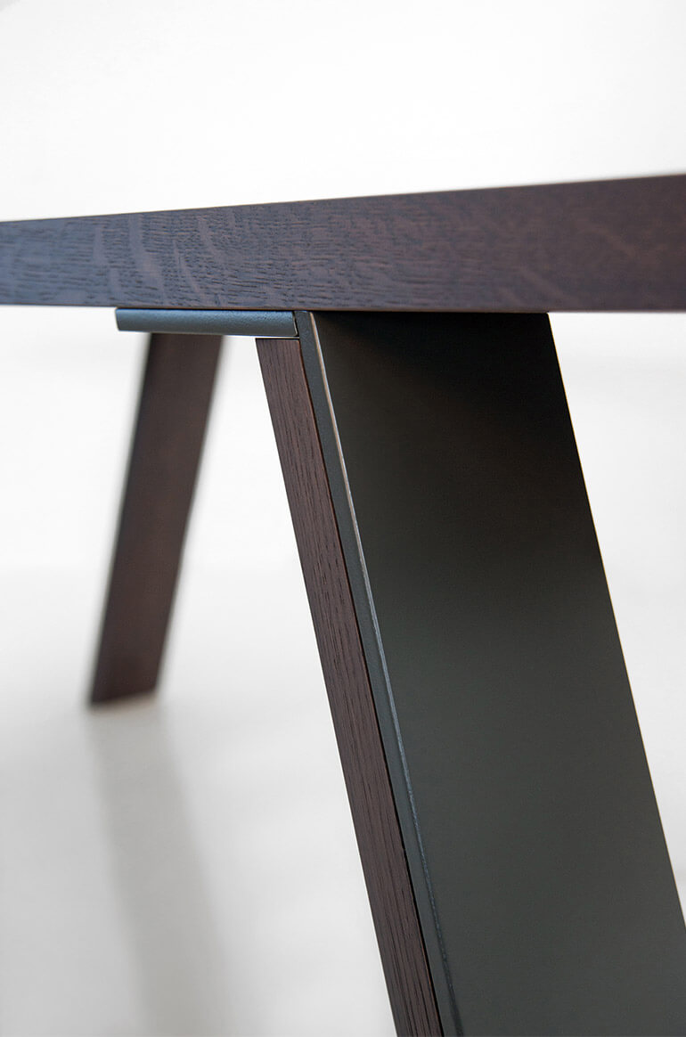 Detail of the leg in metal and dark oak